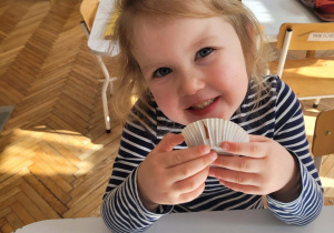 Dziewczynka uśmiecha się jedząc babeczkę