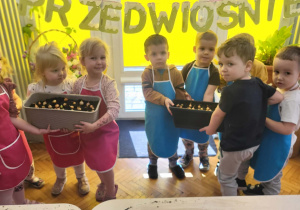 dzieci stoją z donicami