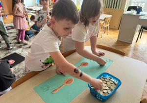 Dzieci rozwiązują zadania matematyczne na łyżkach