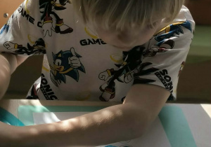 Chlopiec kolorouje zjawiska pogodowe