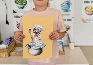 Dziewczynka z pracą plastyczną z kucharzem i garnkiem ze zjawiskami pogodowymi