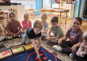 Chłopiec wkąłda d zbioru czerwone rybki