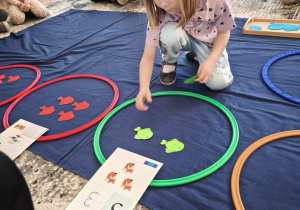 Dziewczynka uklada dwie zielone rybki