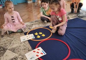 Dziewczynka układa sześć żółtych rybek