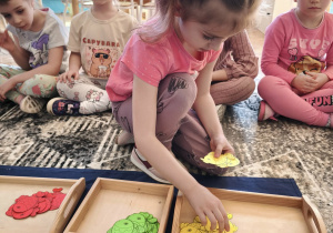 Dziewczynka wybiera żółte rybki z pojemnika