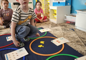 Chłopiec uklada w zbiorze dwie żółte rybki