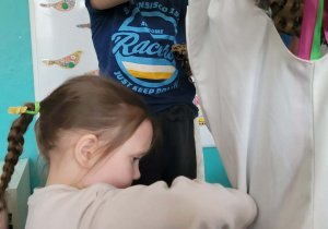 Dziewczynka zapina suknię Marzanny