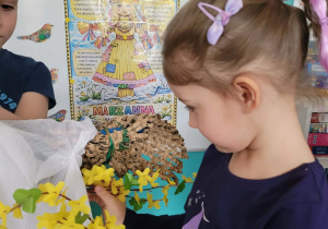 Dziewczynka przyczepia gałązki forsycji