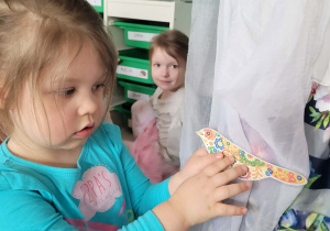 Dziewczynka przyczepia wiosennego ptaszka