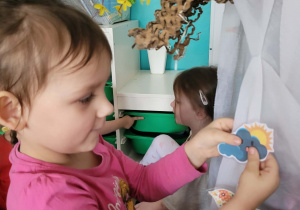 Dziewczynka przyczepia słoneczko zza chmurką