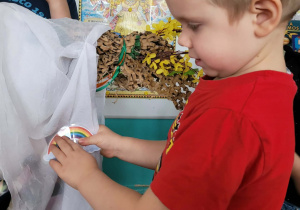 Chlopiec przyczepia tęczę