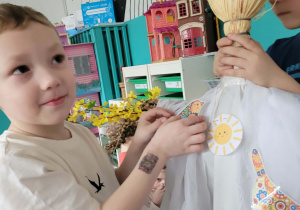 Chłopiec przyczepia wiosennego ptaszka