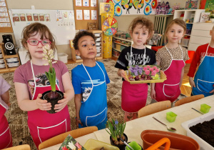 Dzieci stoją z kwiatkami