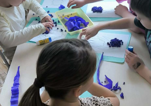 Dzieci niebieską bibułą wyklejają hiacynta