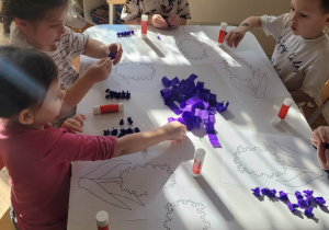 Dzieci robią kulki z fioletowej bibuły