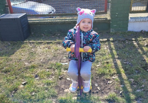 Dziewczynka siedzi ii buja się na dinozaurze