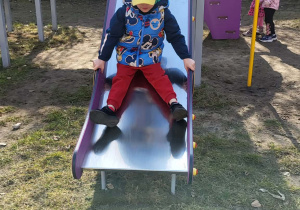 chłopiec zjeżdża ze zjeżdżalni