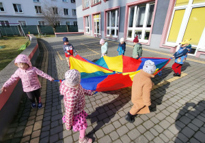 dzieci poruszają się z chustą animacyjną po kole