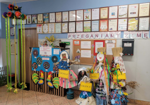 Marzanny stoją na korytarzu pod napisem Przeganiamy zimę