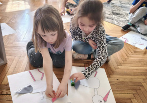 Dziewczynka dokleja dziób bocianowi