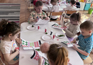 Dzieci przy stoliku wycinają warzywa