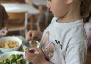 Dziewczynka wkłada do jogurtu owce