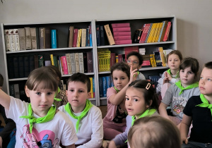 Dzieci siedza na pufach w bibliotece
