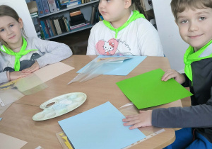 Dzieci siedzą przy stolikach