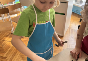 Chłopiec wkłada cebulkę tulipana do doniczki