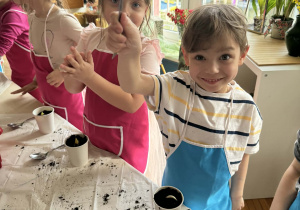 Chłopiec z łyżką w ręce i zasadzoną rośliną