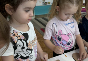 Dzieci malują klejem sklejkę jajka