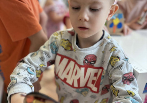 Chłopiec pokazuje swoje jajko wielkanocne z naklejkami