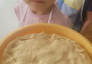 Dziewczynka wącha ciasto drożdżowe