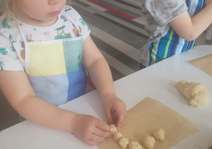 Dziewczynka robi kulki z ciasta