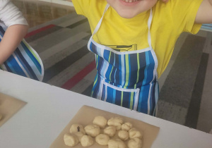 Chłopiec z kulkami ciasta formuje baranka