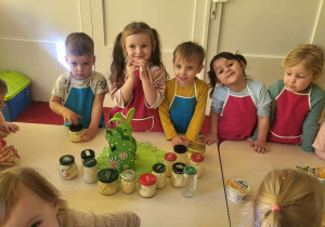 dzieci stoją przed stołem ze słoikami