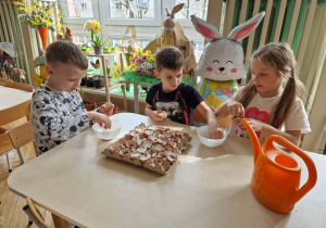 Dzieci przy stoliku sieją rzeżuchę