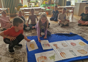 Dzieci kładą ilustracje pisanek i pisklaka