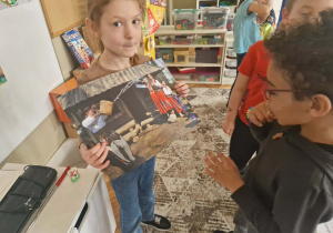 Dziewczynka trzyma zdjęcie z polewania się woda