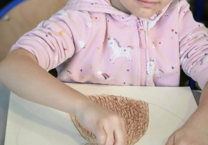 Dziewczynka koloruje królika na brązowo