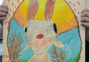 Dziewczynka pikakzuje namalowaną pisankę