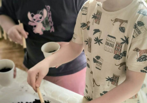 Dzieci wkładają ziemię do doniczek