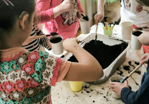 Dzieciwsypuja ziemię do doniczek