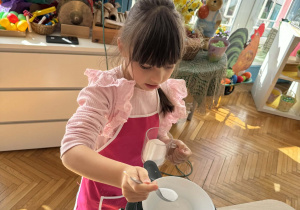 Dziewczynka wsypuje do miski sól