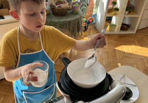 Chłopiec wsypuje cukier