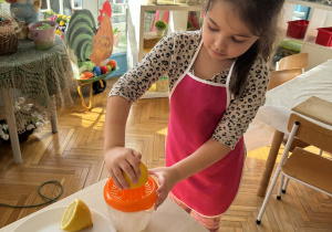 Dziewczynka wyciska cytrynę ręcznie