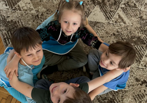 Czwórka chłopców siedzi w małym kole