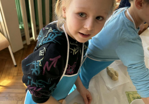 Chlopiec toczy kulę z ciasta