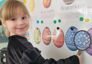 Dziewczynka odszukuje jajko wielkanocne za pomocą lupy