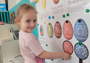 Dziewczynka przyczepia lupę do odszukanego jajka wielkanocnego